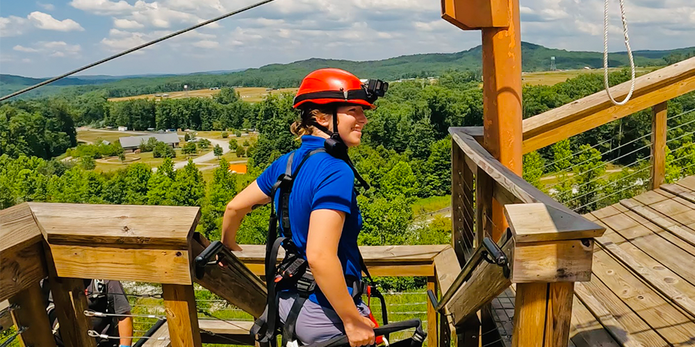 photo of Paige standing on a zip line deck